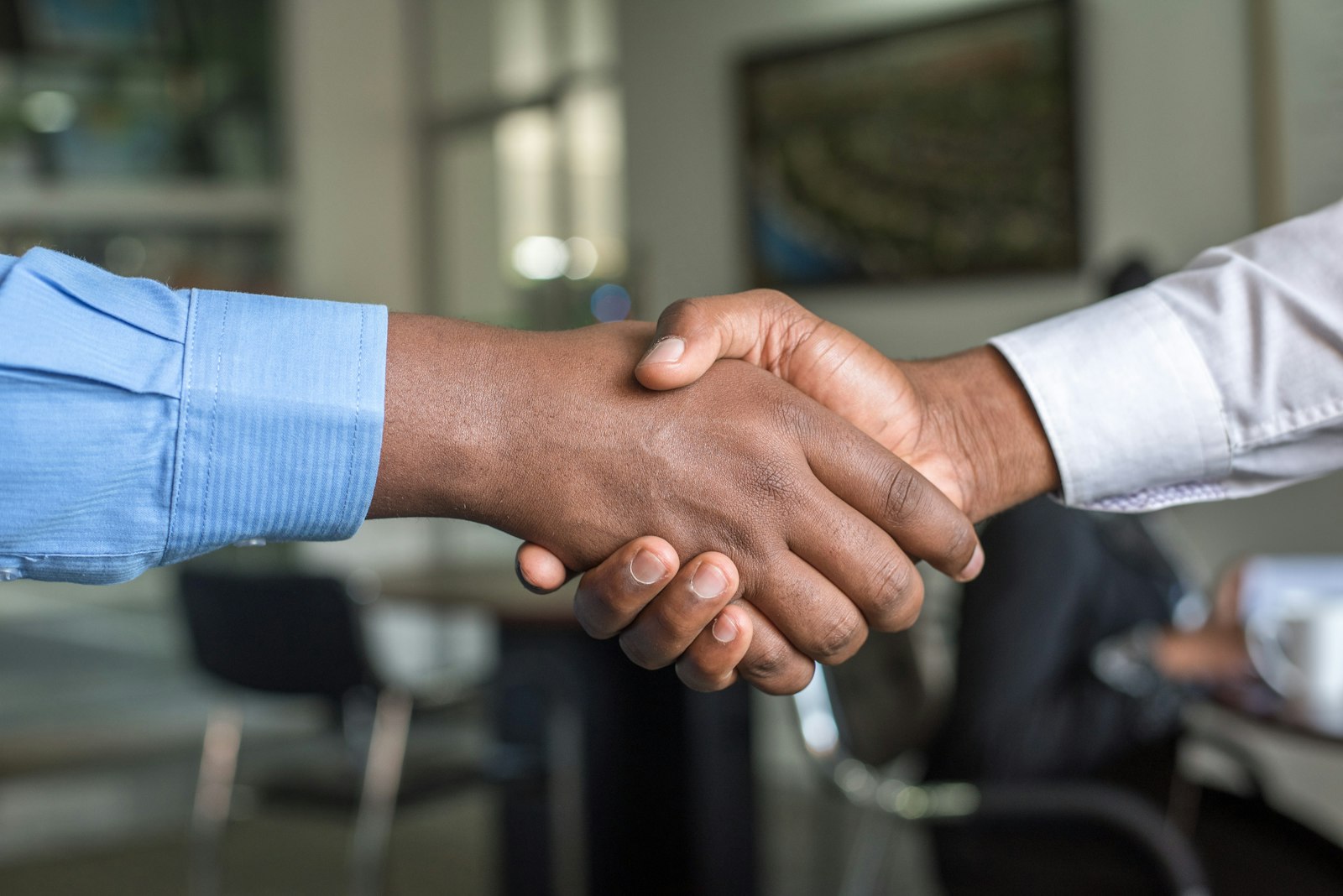 Two business partners shaking hands in a meeting room